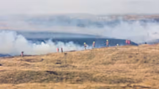 Fire fighters dealing with a large grassfire on an upland moors in Wales