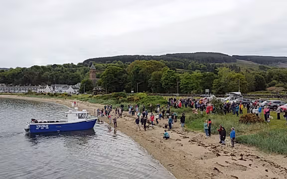 People on the beach at a boat launch.