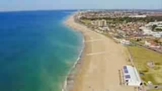 Aerial view of Sussex Bay showing the coastline, with ocean, sandy beach, and surrounding coastal landscape visible from above.