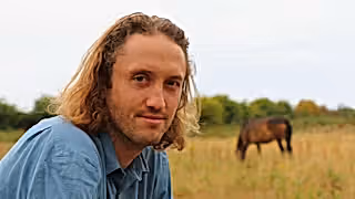 Dominic Buscall with a pony in the background at Wild Ken Hill